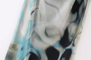Detailed view of light blue smoke-patterned chiffon fabric with artistic abstract print