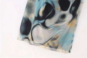 Detail view of semi-transparent mesh fabric with blue and yellow marble print and fine stitching