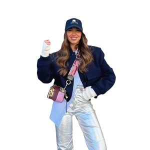 Navy blue bomber jacket styled with Y2K metallic silver pants and a crossbody camera bag