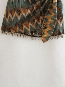 Close-up of bohemian zigzag print skirt hem with colorful beaded fringe details