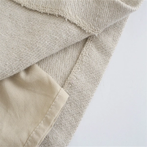 Dettaglio del tessuto di lino beige con trama a saia e rifinitura della cucitura overlock