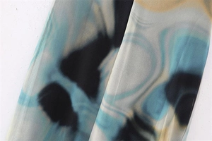 Detail of Y2K vintage floral print on lightweight mesh fabric with abstract blue dye pattern