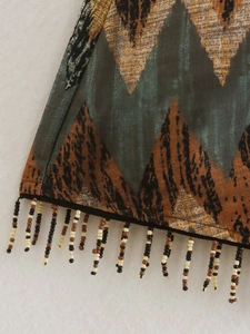 Close-up of high-waisted Y2K skirt hem featuring geometric prints and beaded fringe details