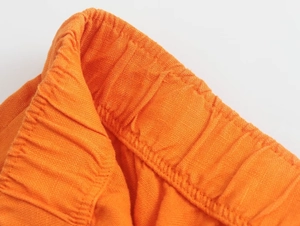 Détail du pantalon en lin orange montrant la taille élastique et les coutures précises