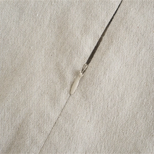 Dettaglio di un tessuto beige intrecciato con una cerniera invisibile di alta qualità