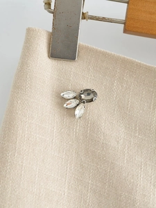Close-up of hand-stitched crystal beads and rhinestone details on beige A-line skirt