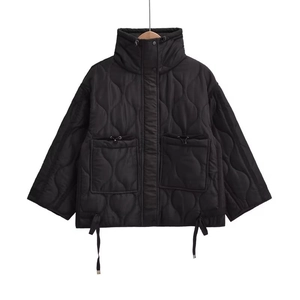 Detail of a black wavy quilted jacket with stand collar and adjustable drawstring pockets