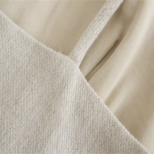 Dettaglio della trama del cotone beige e delle cuciture precise sull'abito estivo