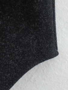 Close-up macro detail of premium black wool blend fabric texture with soft fiber surface