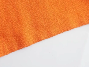 Gros plan sur la texture du tissu en lin orange avec motif de tissage croisé