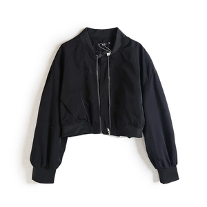 Détail d'un blouson bomber noir court avec fermeture éclair et texture nylon