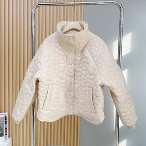 Detail der beige gesteppte Jacke mit Blumenmuster, Stehkragen und Knopfverschluss