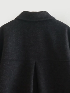 Detailed view of dark grey wool coat featuring a classic lapel and back pleat stitching
