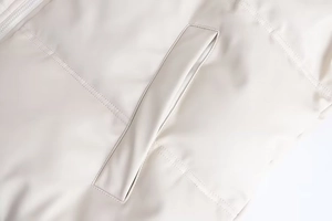 Détail de la veste matelassée Y2K crème montrant la fermeture éclair et la couture de poche