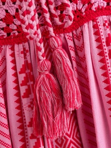 Bohemian Y2K crochet knit slip dress featuring vibrant pink prints and red tassel ties