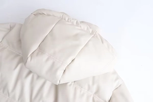 Détail de la capuche arrière de cette doudoune en similicuir crème avec large matelassage