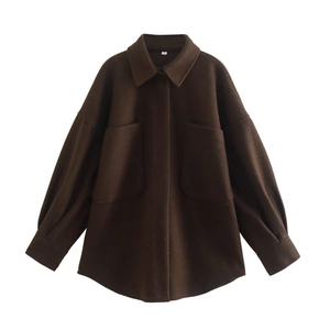 Detail of dark brown oversized wool coat featuring large lapels and front patch pockets