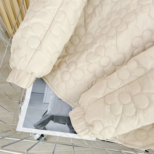 Detailaufnahme der beigen gesteppten Jacke mit Blumenmuster und elastischen Bündchen