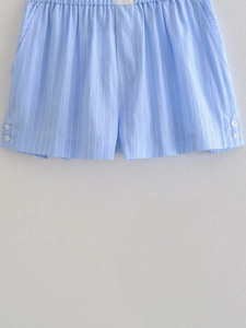 Detail of light blue striped shorts with elastic waistband and white button accents
