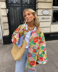 Détail d'une veste matelassée fleurie avec imprimés, boutons en bois et manches à volants