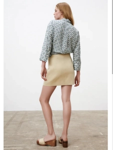 Chic geometric print shirt paired with a beige mini skirt and platform sandals