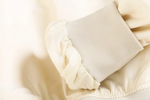 Détail des poignets en tricot côtelé et des manches froncées d'un blouson beige Y2K