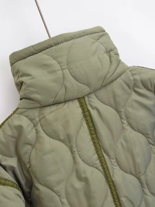 Close-up of olive green quilted jacket showing onion pattern stitching and stand collar