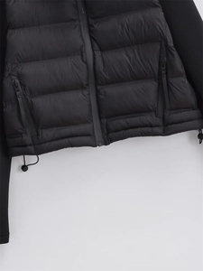 Details vom verstellbaren Kordelzugsaum und Reißverschlüssen der schwarzen Steppjacke