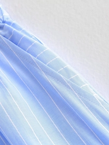 Detailed close-up of blue striped fabric showing pocket seam and elastic waistband texture