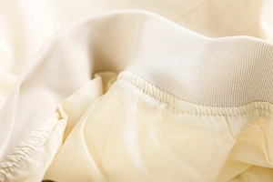 Vue détaillée des poignets côtelés et de la doublure lisse du blouson aviateur crème