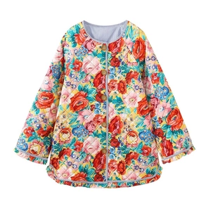 Détail de la veste matelassée à fleurs avec boutons en bois et bordure à volants