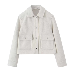 Close-up of beige tweed jacket featuring silver metal buttons and symmetrical flap pockets