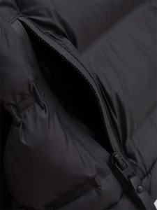 Detail aus wasserdichtem Nylongewebe und Reißverschlusstasche an schwarzer Steppjacke