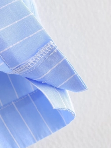Detailed view of the fine stitching and blue striped texture on the Y2K short shirt