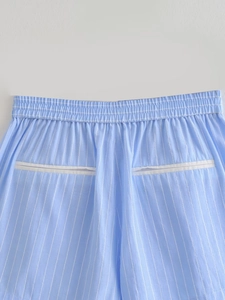 Detail view of elastic ruffled waist and back welt pockets on striped shorts