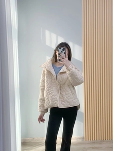 Detailansicht der beigen Steppjacke mit 3D-Blumenmuster und Stehkragen-Design