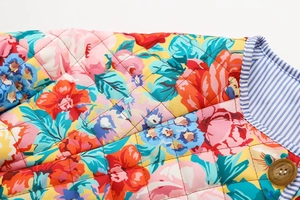 Détails de la veste matelassée à fleurs avec bouton en bois et doublure rayée
