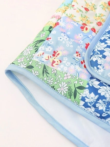 Close-up of floral patchwork quilting and light blue piping on a Y2K padded vest