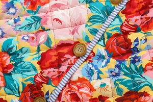 Détail de la veste matelassée fleurie avec surpiqûres en losange et liseré rayé