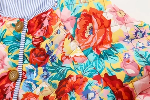 Vue détaillée de la veste matelassée à fleurs avec boutons en bois et doublure rayée