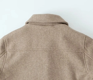 Detail shot of camel wool jacket showing collar stitching and premium fabric texture