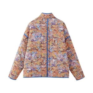 Détails de la veste matelassée Y2K à fleurs avec surpiqûres en losange et bord bleu