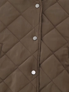 Detailed close-up of diamond quilted brown bomber jacket featuring silver metal snap buttons