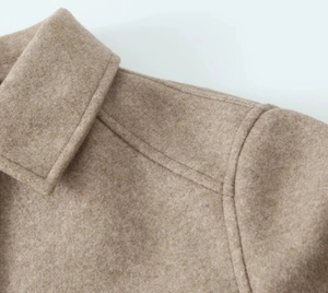 Close-up of camel tweed jacket collar showing thick woolen texture and neat stitching