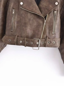 Detail of dark brown faux leather biker jacket hem featuring adjustable buckle belt and zipper