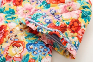 Vue détaillée du tissu matelassé à fleurs avec bordures à volants rayés bleus et blancs