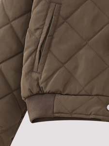 Detailed macro view of diamond quilted brown puffer jacket with rib-knit hem and pocket