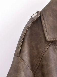 Detail of vintage brown faux leather jacket with epaulettes and sharp lapels
