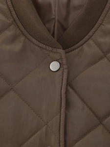 Detail of brown quilted jacket with diamond patterns, ribbed collar and metal snap buttons