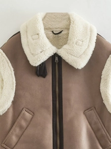 Detail of vintage brown suede vest with white faux shearling lining and metal zipper